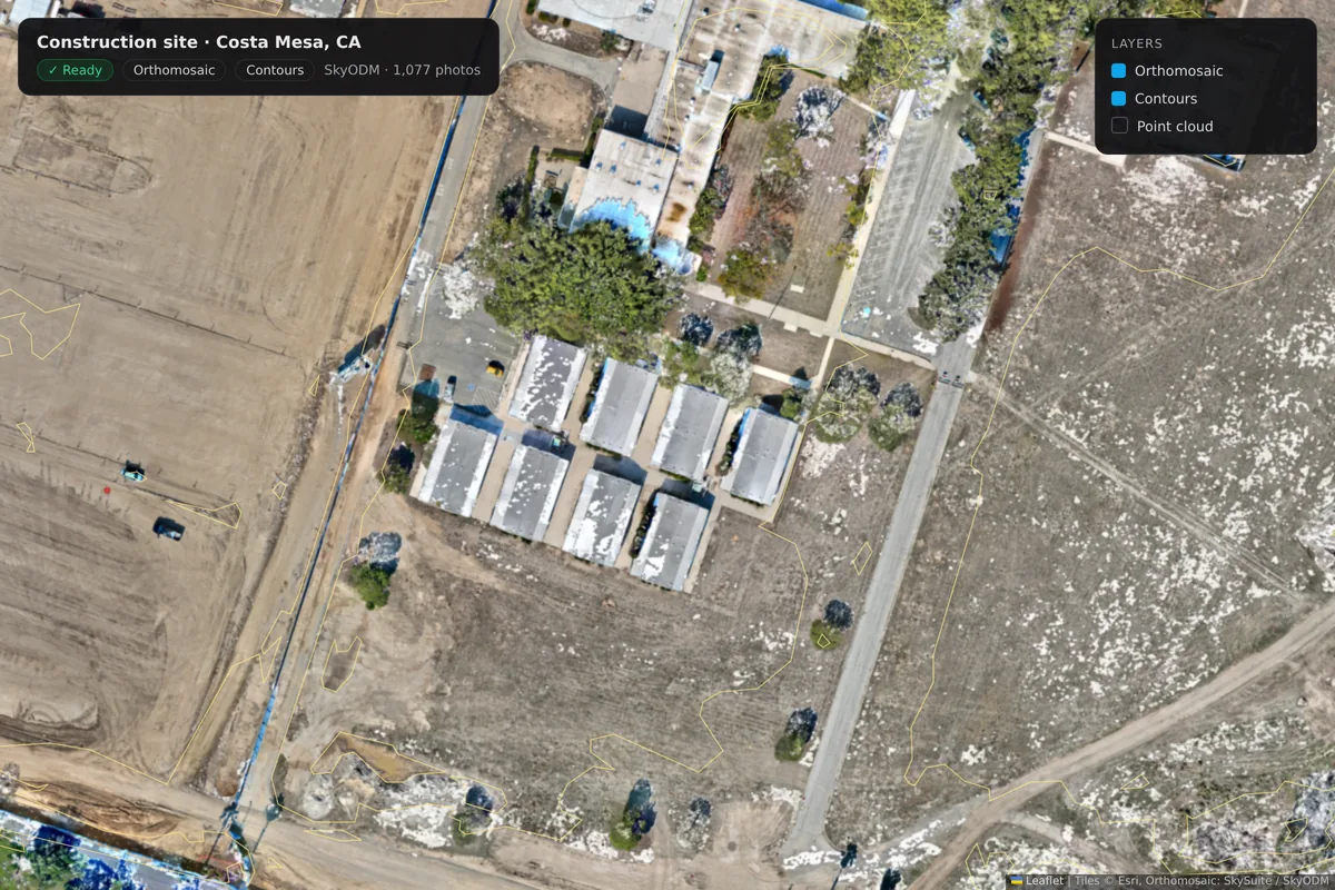 A close-up of the Costa Mesa construction site with contour lines turned on over the orthomosaic: modular buildings, a site road and graded ground.