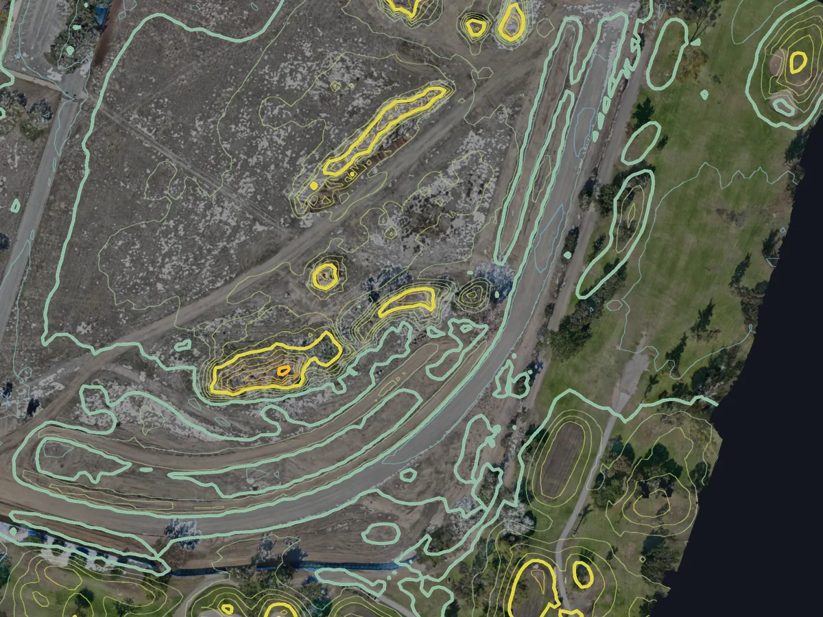 Part of the Costa Mesa site with 1 ft contours over the orthomosaic, tightly ringed around two stockpiles and along the haul road.