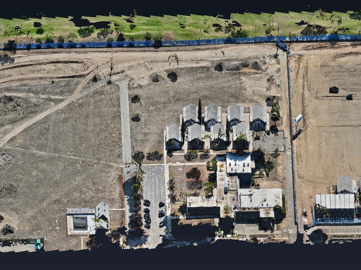 Oblique 3D view of the Costa Mesa point cloud: buildings, the site fence, haul roads, stockpiles and the golf course next door, in true color.